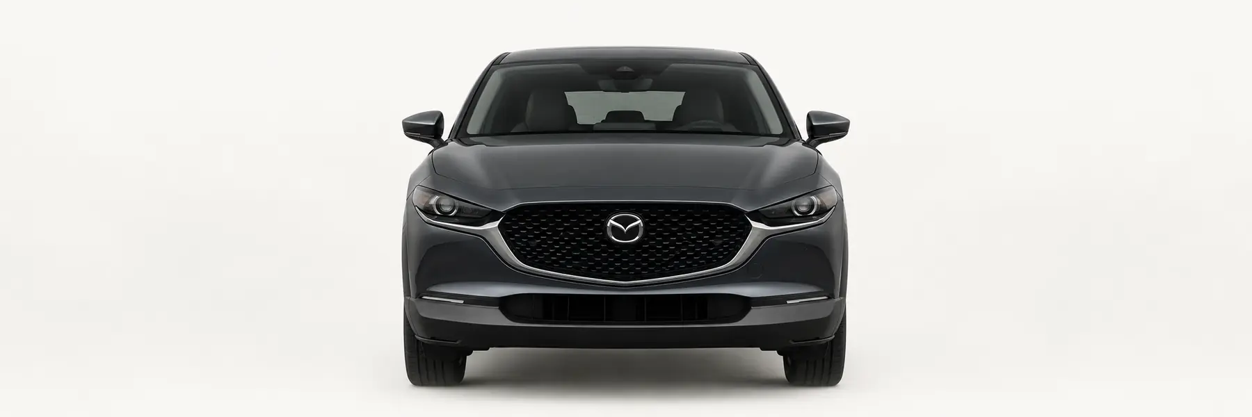 Front view of a graphite Mazda CX-30 DM fading into the page background